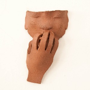 "Hot" by Judith Eloise Harper. In this demonstration of the American Sign Language symbol for the word 'hot,' the figure appears to be soothing his singed fingertips with a cooling breath. Measuring 7" long, 4" wide and 2" deep, "Hot" is made of grog-infused terra cotta-look clay.